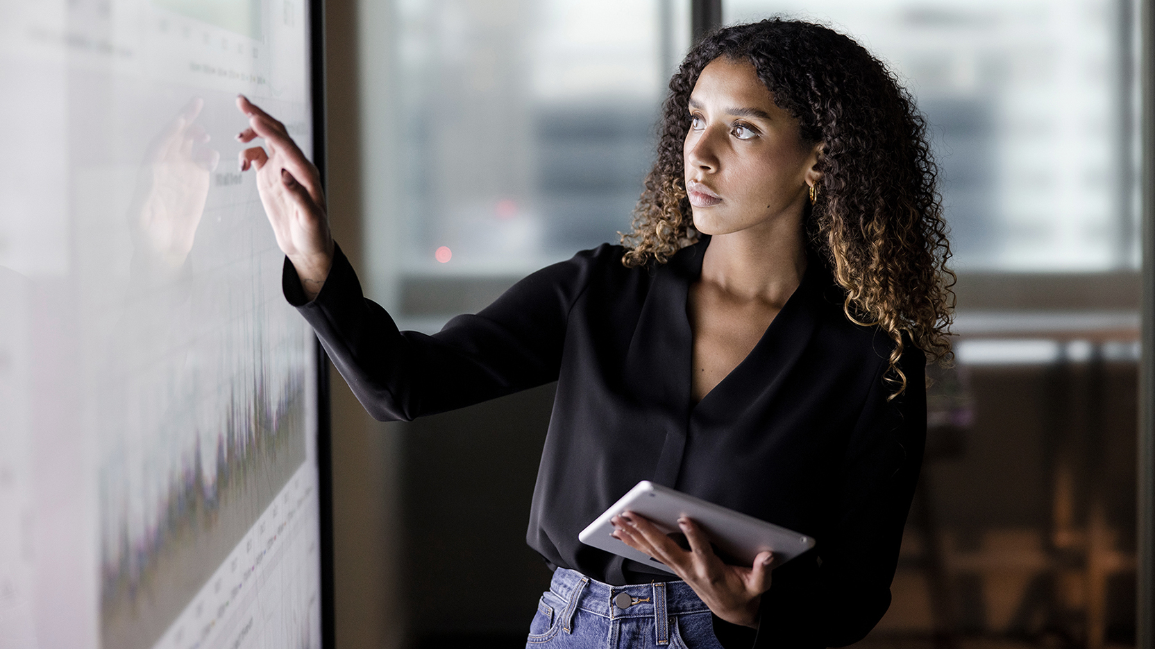 Woman using a tablet along with a touch screen white board