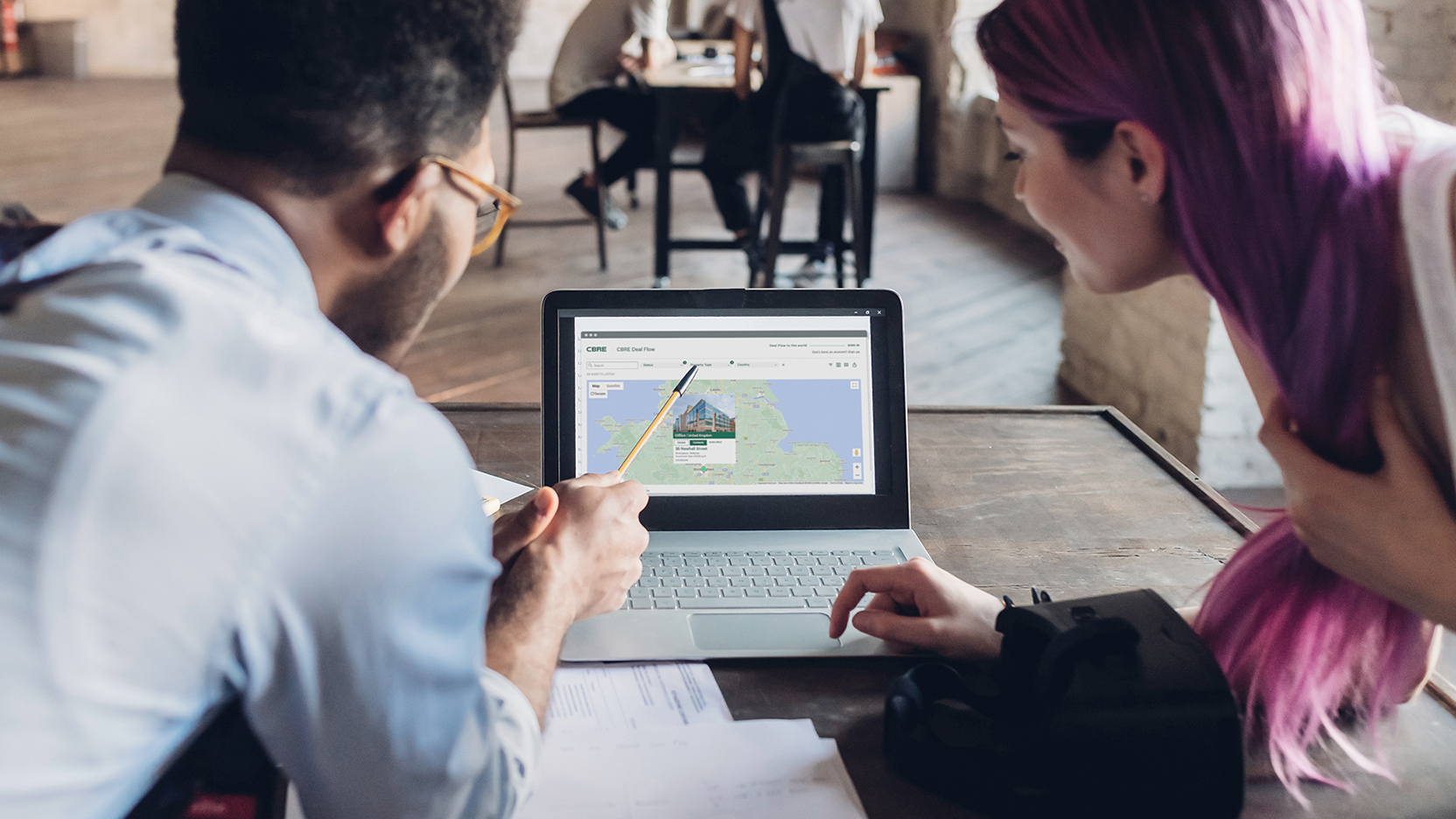 Colleagues viewing CBRE Deal Flow on laptop screen