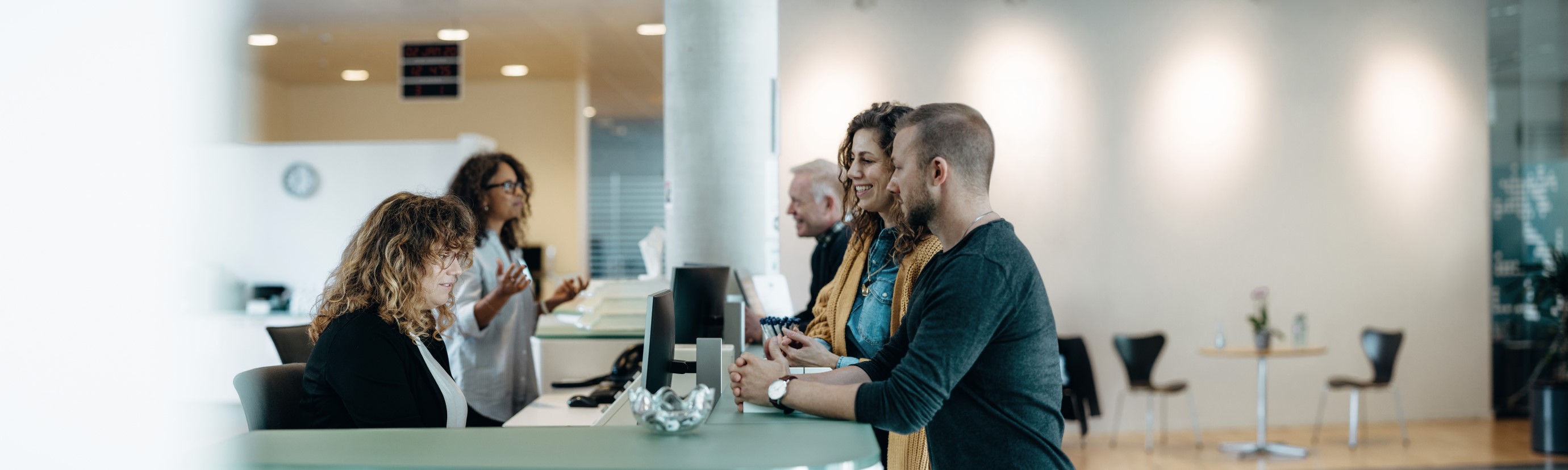 Employees talking to each other around a reception desk area