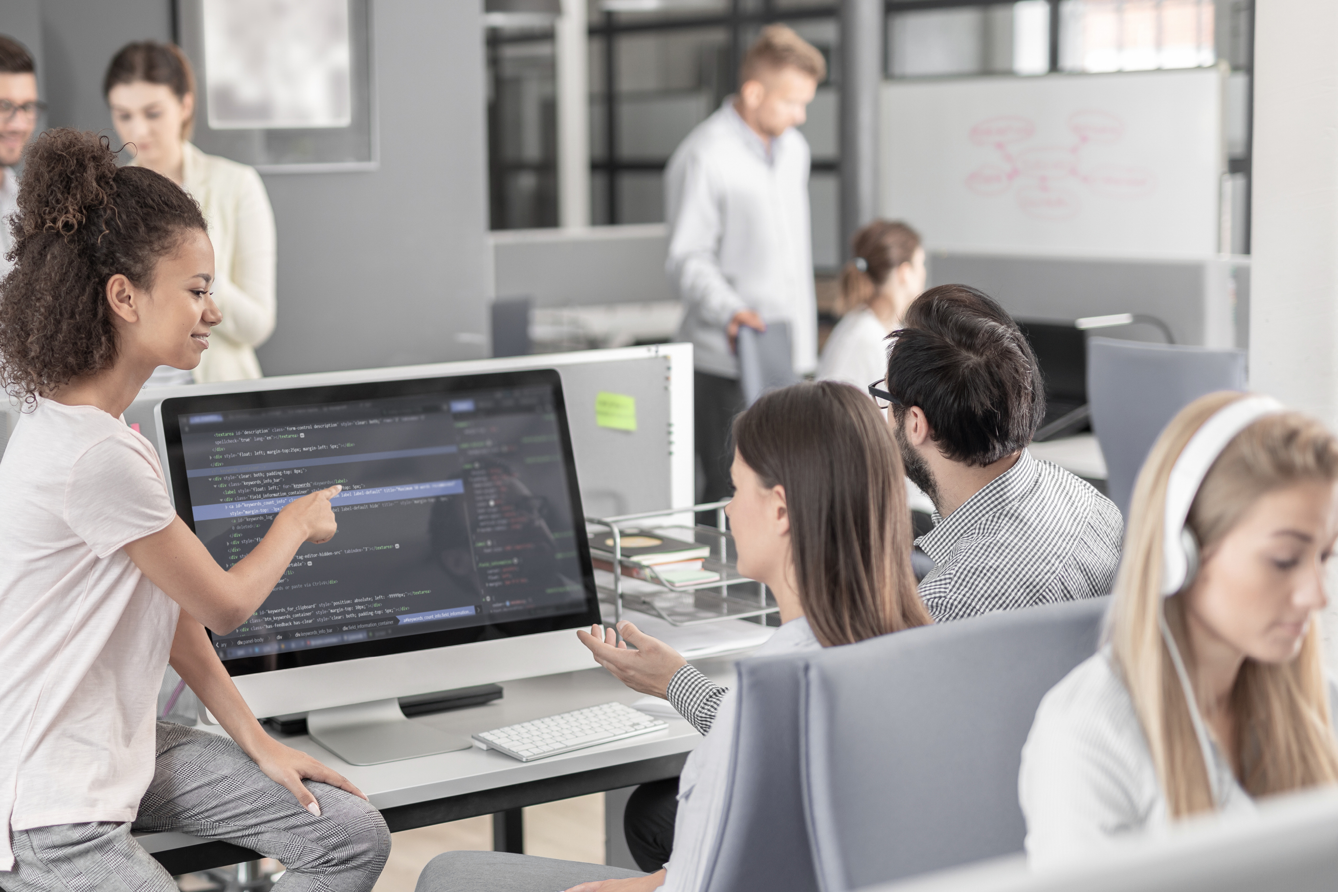 Colleagues gathered at a computer reviewing content